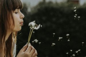Woman blowing flower to show power of breath