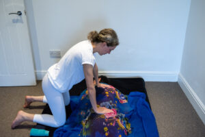 Tatiana Aitken giving tantric massage to client who has come in for yoni massage therapy