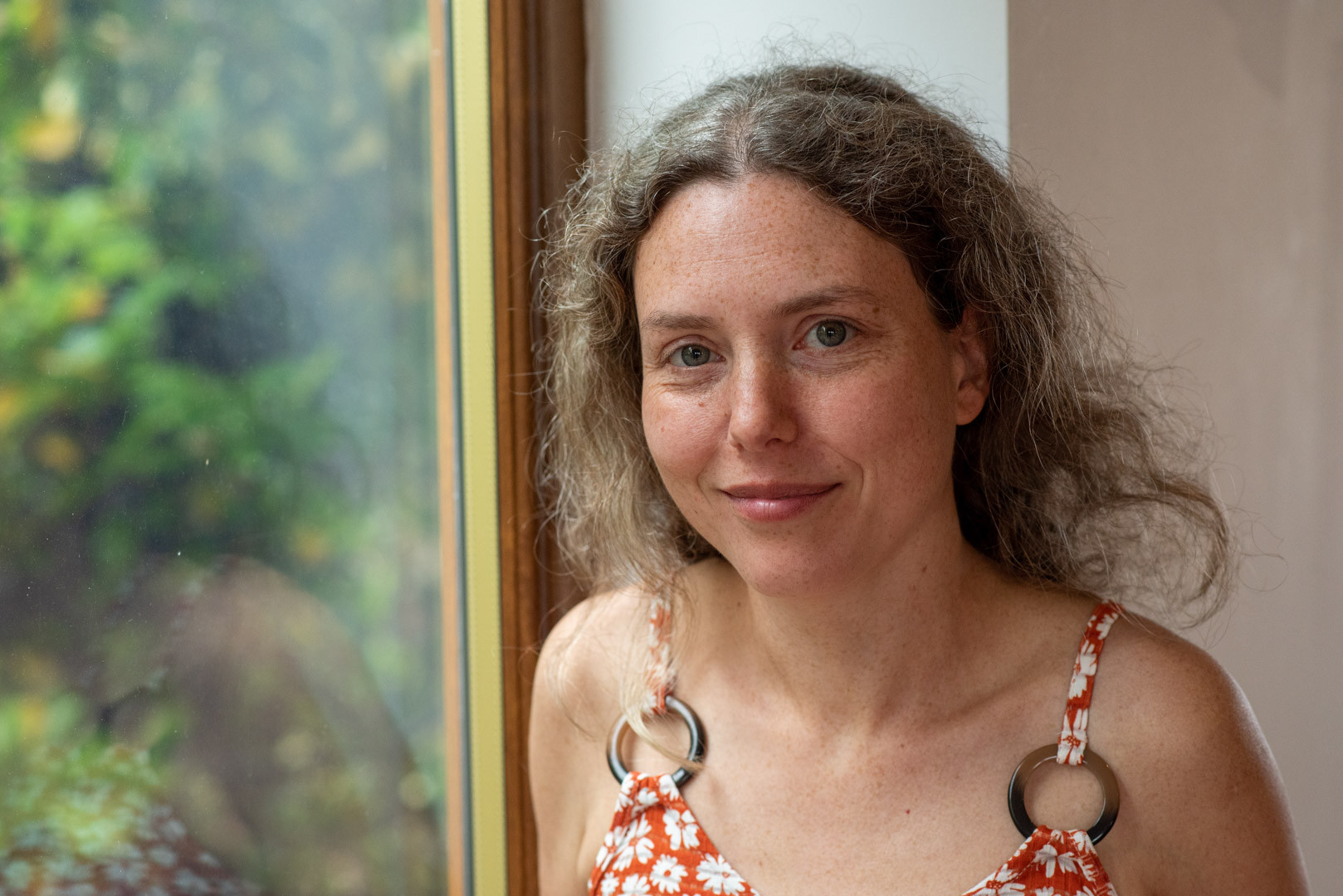 Headshot of Tatiana looking at camera wearing brown dress