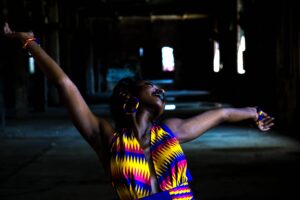 Black woman with arms lifted, expressing joy and full-body orgasmic surrender