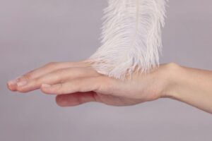 Hand being touched in a sensual way with a feather